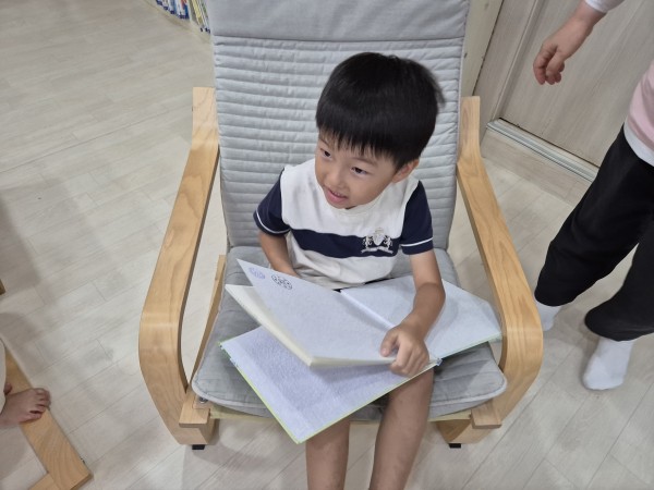 소파에 앉아 책읽는 아동의 모습