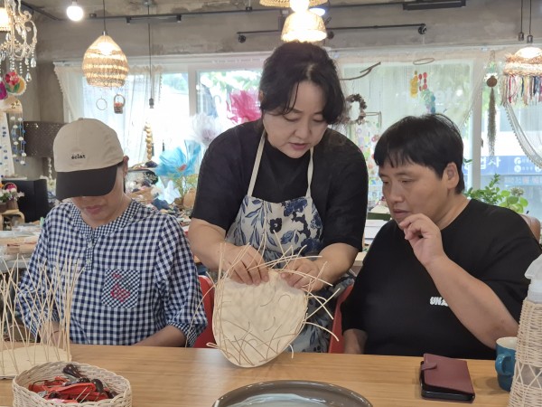 강사의 도움을 받아 라탄바구니를 만드는 모습
