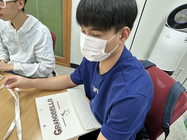 끈과 쇼핑백을 연결하려고 하는 모습