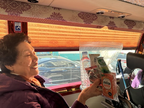 버스에서 간식꾸러미 받는 이용인