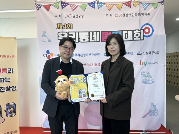 나눔증서와 인형을 들고 사진을 찍고 있는 모습