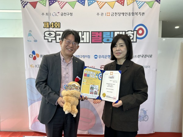 나눔증서와 인형을 들고 사진을 찍고 있는 모습