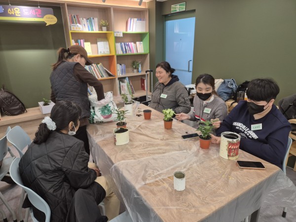 식물을 선택하고 화분에 옮겨심는 모습