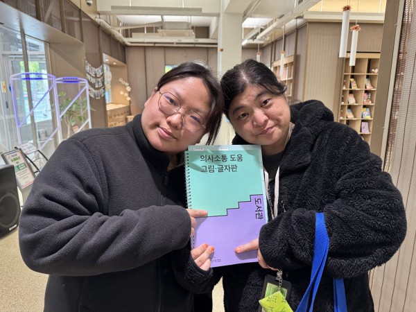 쉬운그림글자판을 들고 사진찍는 모습