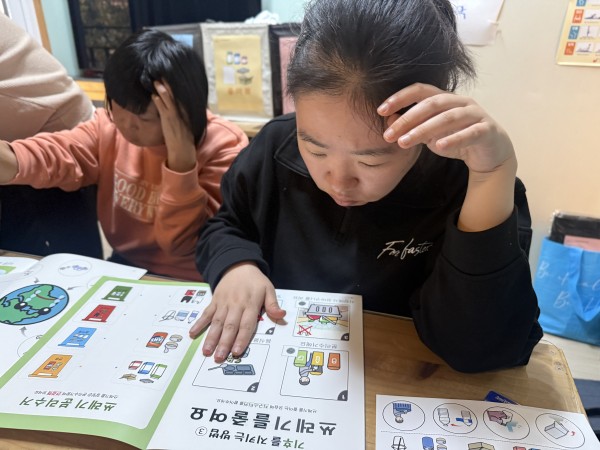 AAC 책자를 집중해서 보는 볕바라기 이용자모습