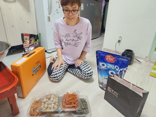 전달받은 반찬을 바라보는 보호자