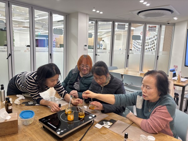 보호자 분들이 서로 이야기하며 화장품을 만들고 있는 모습의 사진