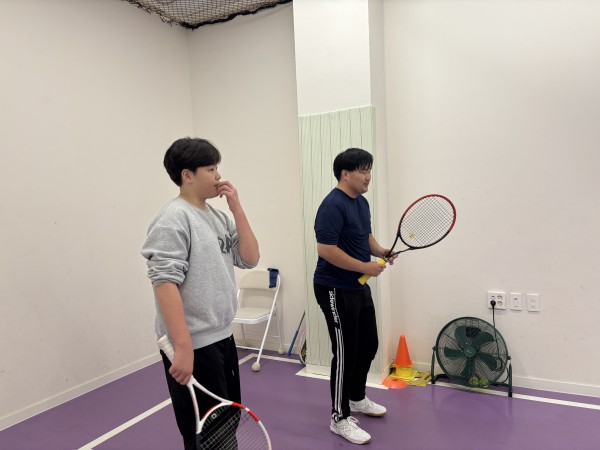 동생과 당사자가 테니스 수업을 열심히 듣고 있는 모습