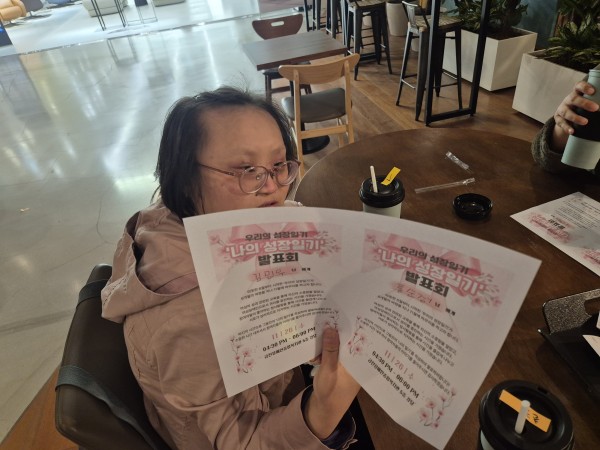 초대장을 들고 사진을 찍는 모습