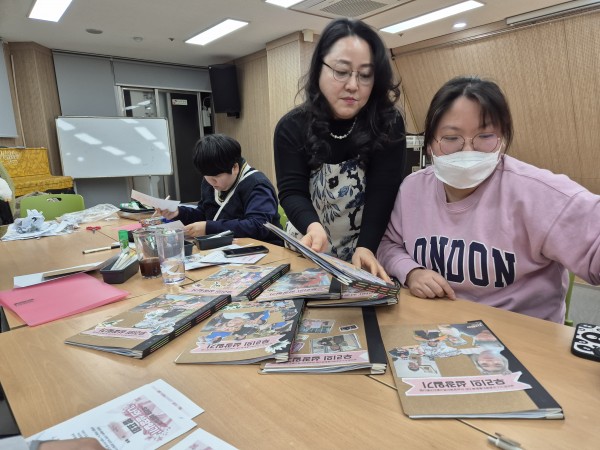 강사의 도움을 받아 나만의 성장일기를 만드는 모습