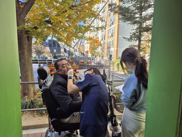 스쿠터타고 바깥에서 구강검진받는 모습