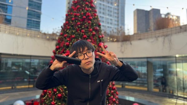 크리스마스트리 앞에서 브이하며 사진찍는 이용인