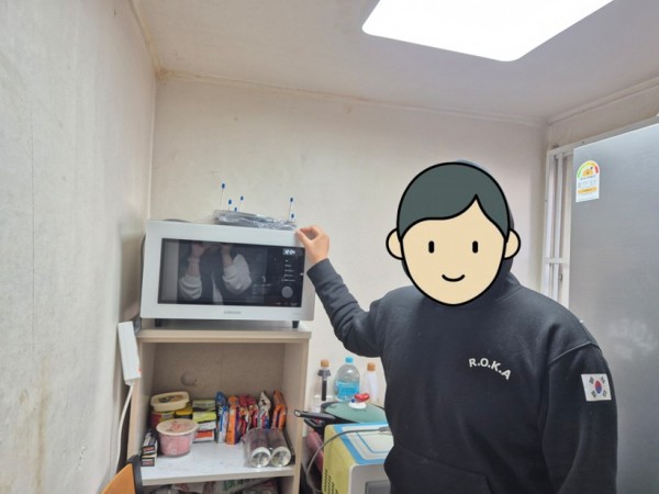 새로운 전자레인지와 사진을 찍는 아동의 모습