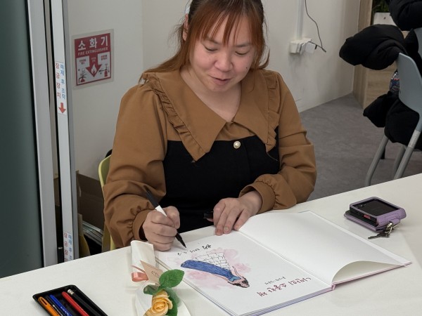 직접 만든 동화책에 서명하는 모습