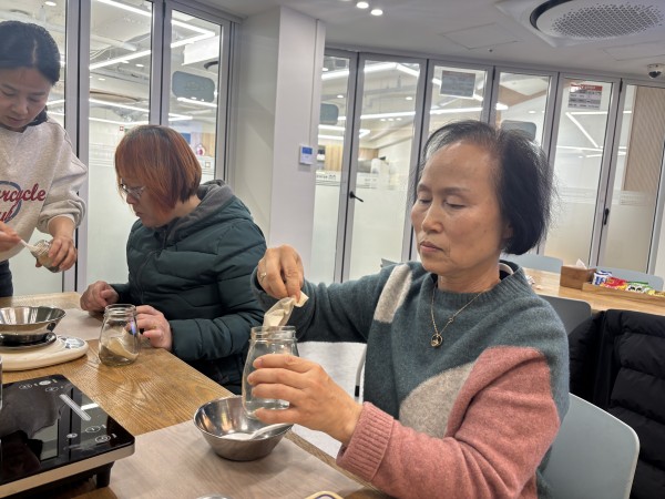 보호자 분이 용량을 맞춰 그릇에 담아내고 있는 모습의 사진