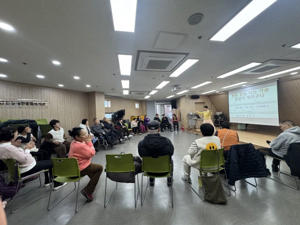 활동지원사, 이용인 보호자, 이용인이 함께 즐기고 있는 노래교실의 모습