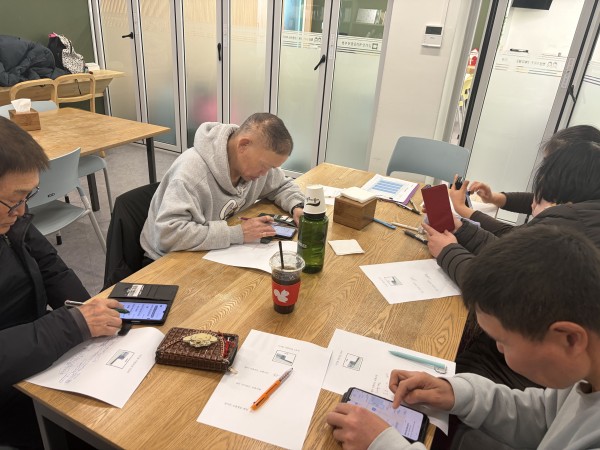 핸드폰으로 디지털 연습하는 참여자들