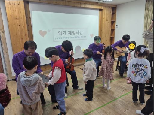 장애인식개선강사님이 횡성영재어린이집 아이들에게 직접 악기에 대해 알려주고 체험할 수 있도록 도와주고 있는 모습