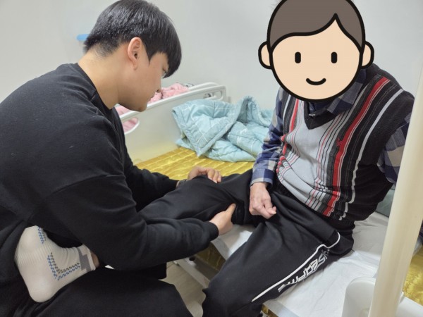 치료사가 이용인의 마비측 다리를 운동시키고 있다