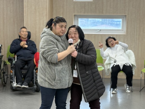 참여자가 마이크를 잡고 노래를 부르는 모습