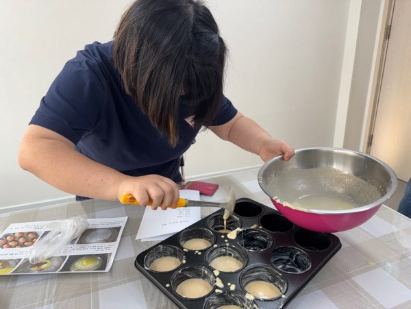 집중하여 틀에 반죽을 붓는 모습