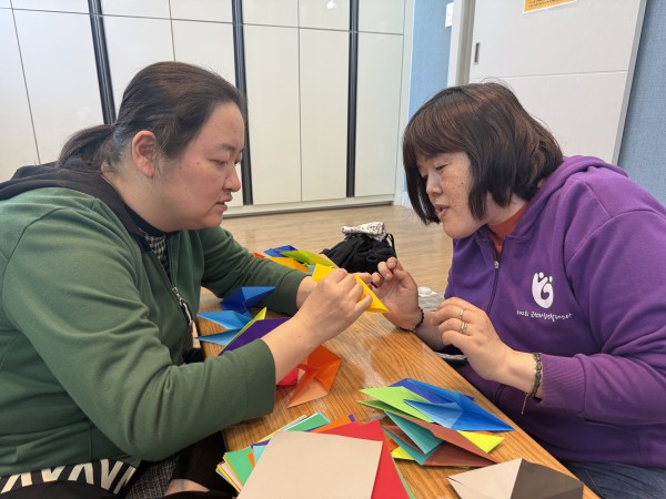 신규참여자가 종이접기를 알려주고 있는 모습