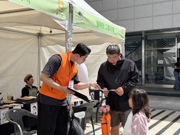 체험북 안내하는 봉사자 모습