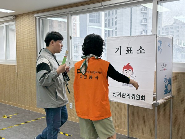 투표 안내하는 봉사자 모습