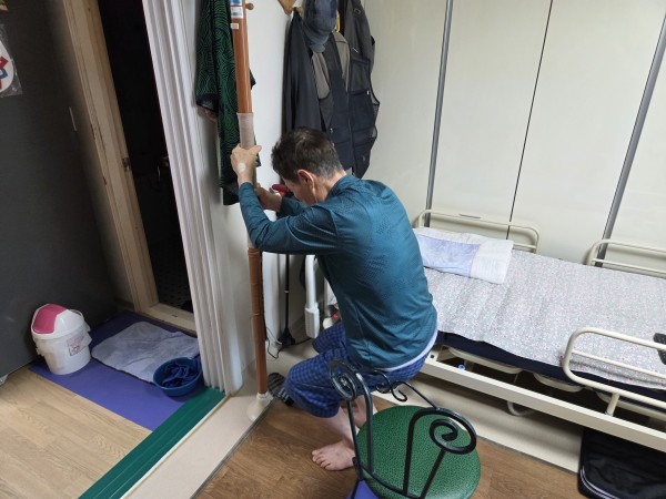 가정 내 안전 손잡이를 활용한 하체 운동을 하고 있다.