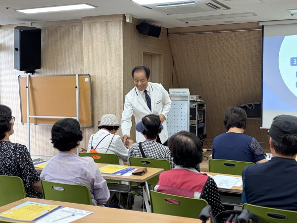 참여한 이용인과 강사님이 악수하는 모습