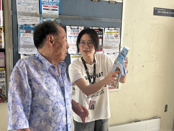 지역주민들에게 내일 행사를 홍보하는 실습생