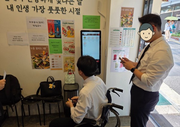 휠체어를 타고 가게로 진입하는 모습