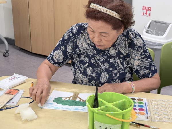 스펀지를 홣용하여 배경을 색칠하고 있는 모습