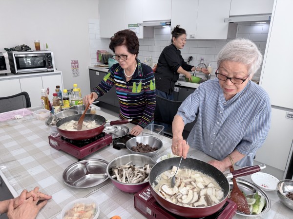 서로 간을 봐주며 탕을 끓이고 있는 모습