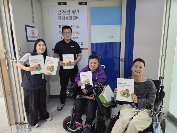 금천장애인자립생활센터에서 다함께 가이드북을 들고 사진 찍는 모습